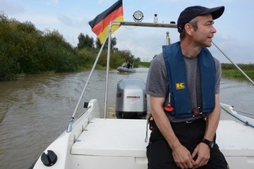 Foto 1: Uwe de Vries vom Ingenieurbüro IDV Greetsiel bei der Anfahrt zur Bohrplattform. Das Boot wird von der Wasserschutzpolizei (im Hintergrund) begleitet.