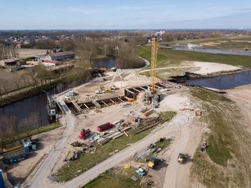 Vogelperspektive: Die Baustelle aus der Luft mit der Baugrube, in der noch das Wasser steht.