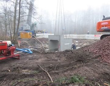 Auch das Platzieren der sogenannten Hauben auf dem Fundament erforderte wieder höchste Präzision. Damit die Baugrube nicht mit Wasser volllief, wurde kurzzeitig das Wasser abgepumpt.