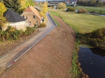 Der verstärkte und erhöhte Deich auf Höhe der ehemaligen Mühle in Hönisch. Erkennbar ist der neue Deichverteidigungsweg mit der Winkelstützmauer und einer befestigten steileren Böschung als technische Sonderlösung für die beengten Platzverhältn