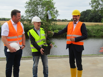 Minister Lies kam nicht mit leeren Händen nach Otterndorf: An NLWKN-Betriebsstellenleiter Martin Kogge und Projektleiter Andreas Kosch überreichte er als Geschenk einen klimaresilienten Baum.