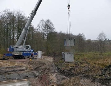 Tonnenschwere, speziell angefertigte Betonbauteile wurden für den Rohrdurchlass mit dem Schwerlastenkran angehoben und positioniert.