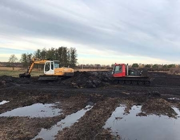 Moorraupe beim Dämmebau (rechts im Bild) in Aktion. Diese Spezialmaschine wurde eigens für den Landschaftsbau konstruiert, um die Vegetationsdecke bei Befahrung möglichst wenig zu schädigen.