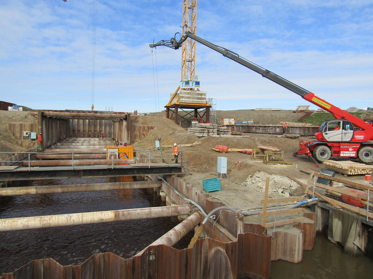 Blick in die künftige Schleusenkammer: Die gegenwärtig durchgeführten Vorbereitungsarbeiten für den Einbau der Unterwasserbetonsohle finden zu einem großen Teil unter Wasser statt. Der Krahn lässt hierzu eine Saugpumpe in die Kammer ab.