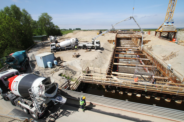 Betongussarbeiten an der Schleusenkammer in Otterndorf: Betonmischer fahren heran, um den Beton in die Baugrube zu gießen.