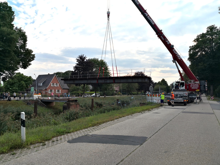 Per Schwerlastkran schwebte die sanierte Brücke am Mittwochabend in Georgsdorf ein.
