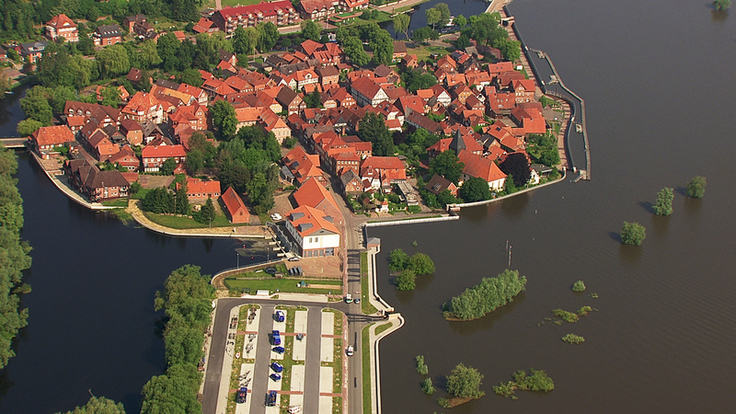 Luftbild: Die Altstadt von Hitzacker im Mittelpunkt des Bildes. Links und rechts schließen die Fluten der Elbe und der Jeetzel den historischen Stadtkern ein.