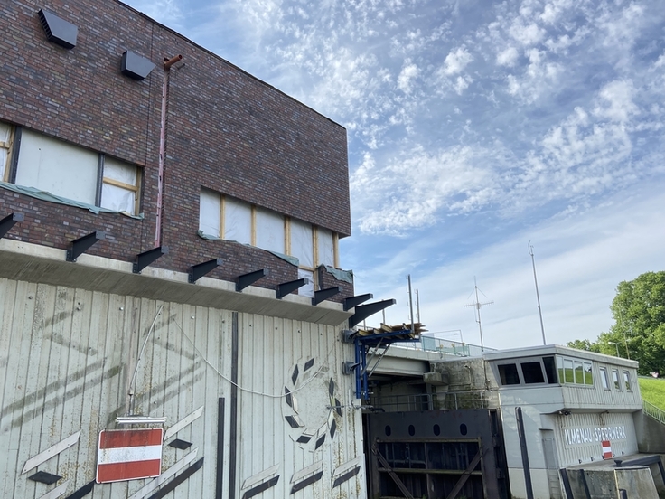 Blick auf die Baustelle: Das neue Betriebsgebäude steht in Gerüst und im Rohbau da, rechts das eigentliche Sperrwerk.