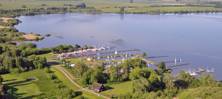 Luftbild vom Dümmer. Vorne eine Marina, weiter hinten der See und Grünland.