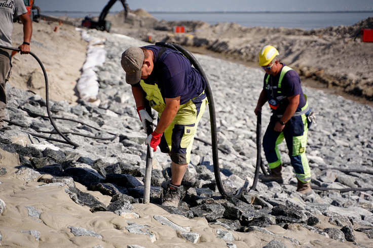 Die Schüttsteine unterhalb und oberhalb der Asphaltberme werden mit Spezialmörtel vergossen und so zusätzlich gegen die starke Beanspruchung durch Wellen gesichert (Foto: Lippe/NLWKN).