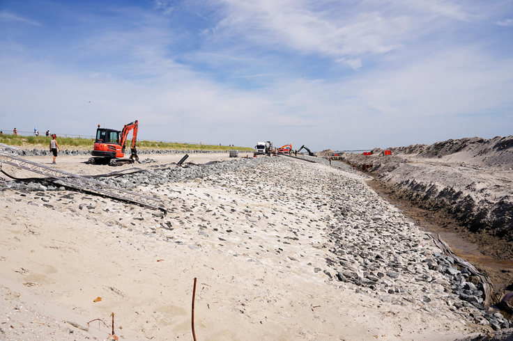 Die erste Hälfte des Küstenschutzprojekts konnte bereits 2021 fertiggestellt werden. Aus Rücksicht auf den Tourismus arbeitet sich die Baustelle derzeit vom Weststrand weg in Richtung Hafen vor (Foto: Lippe/NLWKN).