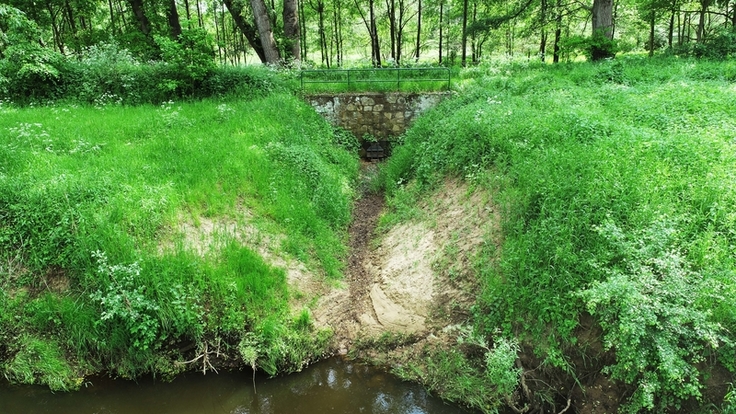 Die aktuelle Situation am Rohrdurchlass bei normalem Wasserstand (1) und Hochwasser (2). Nach Umsetzung der Arbeiten steht die hinter der Verwallung liegende Naturschutzfläche wieder für die Hochwasserrückhaltung und Auenentwicklung zur Verfügung.