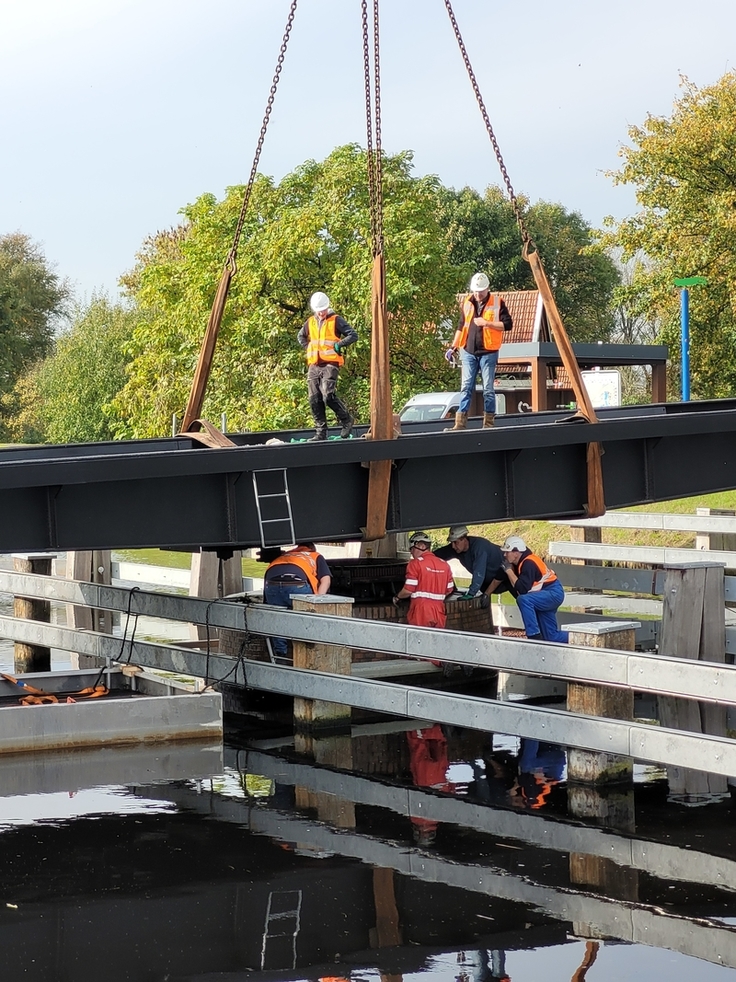 Mit Hilfe eines 500-Tonnen schweren Spezialkrans wurde das erneuerte Drehelement auf den in der Mitte des Ems-Jade-Kanal stehenden Brückenpfeiler an der Uphuser Klappe gehoben und dort mit 52 Spezialschrauben fixiert.