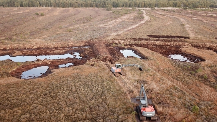 Die Entnahmebereiche, aus denen das Material für den Dammbau gewonnen wird, füllen sich bereits während der Bauphase wieder mit Wasser. Dies zeigt, wo der Wasserstand des Torfköpers zu diesem Zeitpunkt (Oktober 2022) stand.
