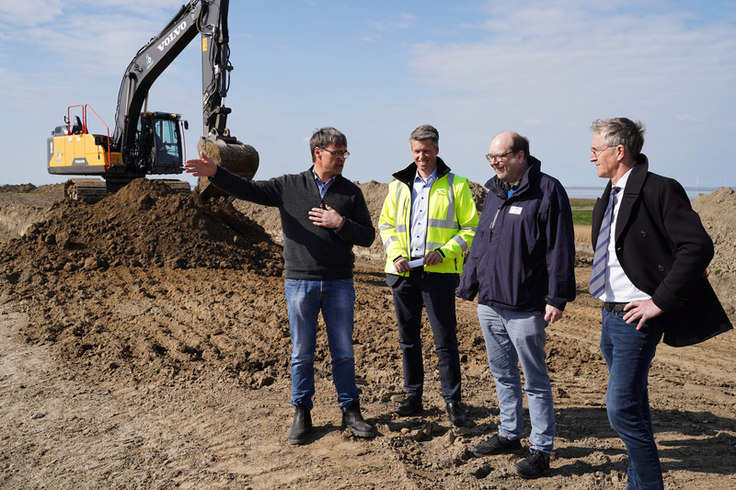 Auf der Deichbaustelle bei Hamswehrum rollen bereits die Bagger. Umweltminister Christian Meyer (3.v.l.) machte sich am Donnerstag gemeinsam mit Experten von NLWKN und Deichacht Krummhörn ein Bild vom Fortschritt des Großprojekts (Bild: NLWKN).