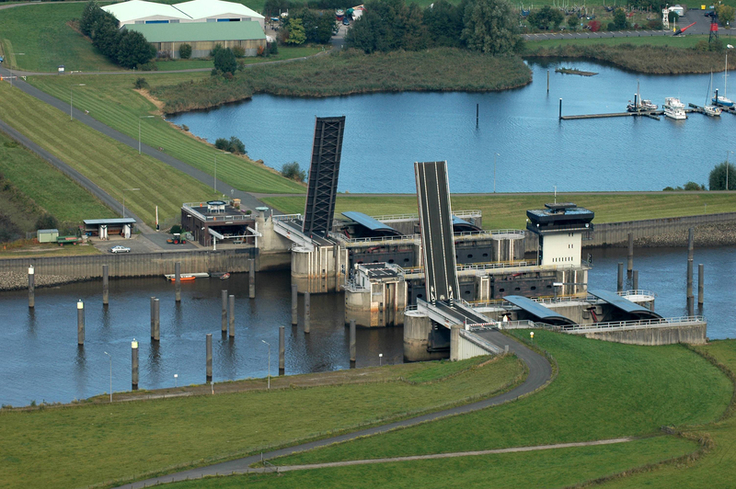 Das 120 Meter breite Huntesperrwerk aus der Luft: Vier mächtige, konvex gebogene Sperrtore können bei Sturmflut geschlossen werden und schützen so das Hinterland vor Überflutung (Bild: NLWKN).