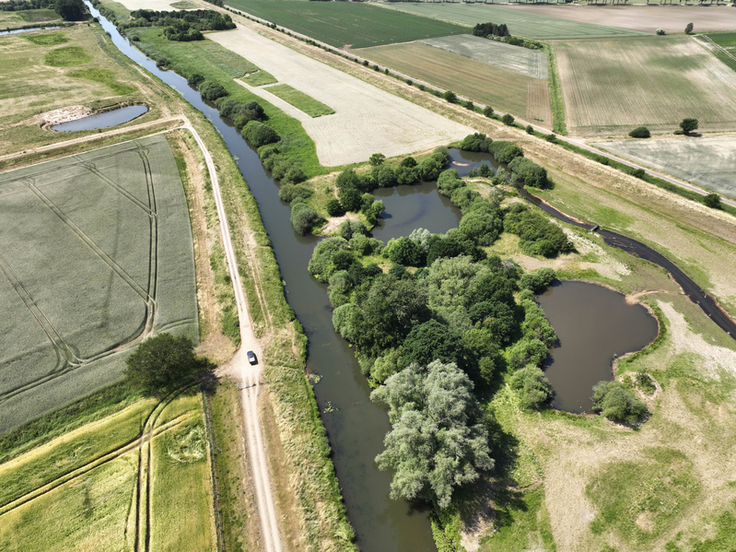 Rund 13 Kilometer Deiche und Dämme der Hase sind wie hier unten im Bild bereits saniert – für einen letzten Teilabschnitt rollen nun die Baugeräte an. Rechts im Bild: die Revitalisierungsmaßnahme der NWA, (Bild: Lamping).