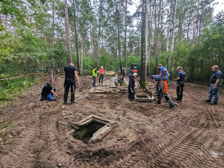 Engagement am Ort unvorstellbarer Gräueltaten: Unter Anleitung von NLWKN-Ausbildern und Mitarbeiterinnen und Mitarbeitern der Gedenkstätte Bergen-Belsen richten die Auszubildenden des Landesbetriebs Fundamente einer Latrinenanlage her (Bild: Lina Krüg