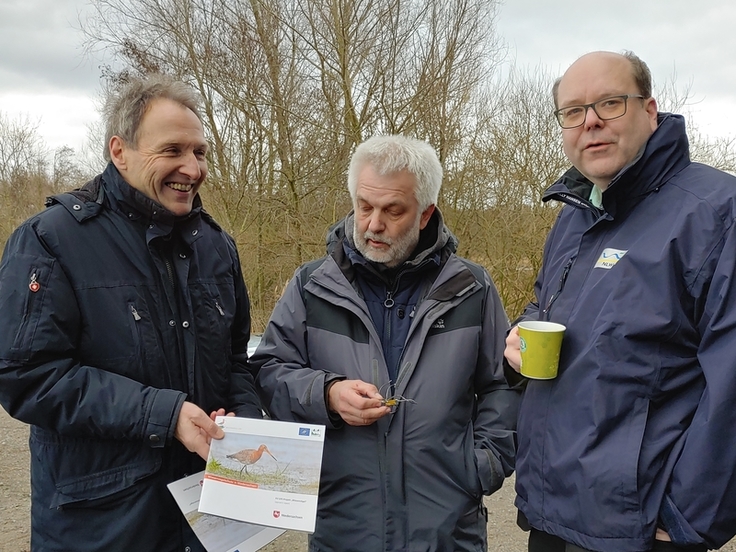 Berthold Paterak (stellv. Direktor NLWKN, links) und Jürgen Ludwig (Staatliche Vogelschutzwarte und Projektleiter des LIFE-Projektes Wiesenvögel, Mitte) überreichen Niedersachsens Umweltminister Christian Meyer (rechts) die gerade gedruckte Broschüre