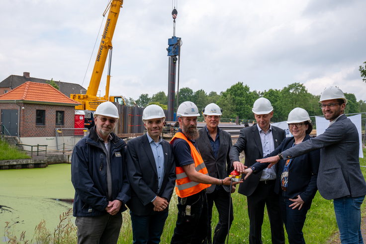 Lösten gemeinsam in Uplengen den ersten Rammschlag aus (v.l.n.r.): Axel Daubenspeck, Jörn Drosten (beide NLWKN), Polier Jann Warfsmann, Klaus Kieseling (NLWKN), Heinz Trauernicht (Gemeinde Uplengen), Anne Rickmeyer und Sven Lübbers (Stadt Wiesmoor).