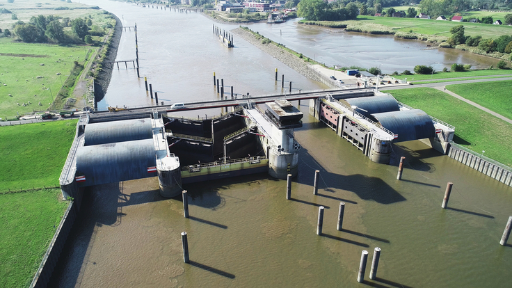 Blick von oben: Das Huntesperrwerk schützt die Wesermarsch, Oldenburg und Bremen seit 1969 vor Sturmfluten – nun mit neuer Steuerungstechnik (Foto: Dirks/NLWKN).