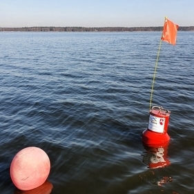 Mitten im Wasser des Steinhuder Meeres schwimmt eine rote Gütemessboje.